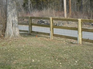 3 rail paddock pressure treated style fence with posts pinned to solid ledge