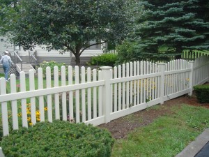 Tan vinyl fence with dog ear pickets and new england post caps crowned style sections