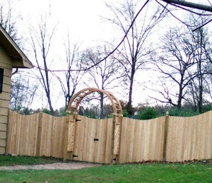 White cedar scalloped dog eared privacy fence with cedar grand arbor